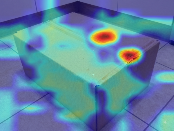 Forensic heatmap of the same water-damaged box photo, with the AI-edited region highlighted