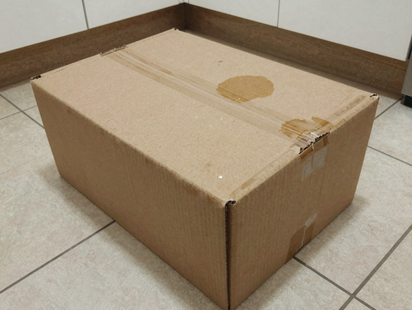 Cardboard box with brown water stains on the lid — the photo the customer submitted with their refund claim