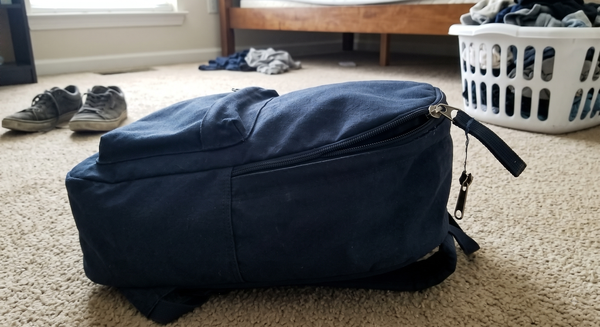 Navy backpack lying on carpet — the photo the customer submitted with their refund claim